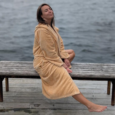 Woman in a robe at a lake relaxing